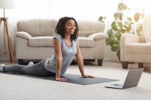woman exercising at home to an online fitness class