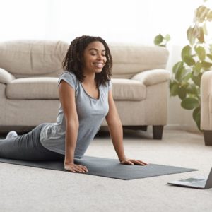 woman exercising at home to an online fitness class