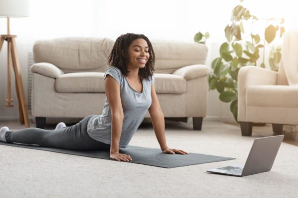 woman exercising at home to an online fitness class